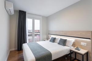 a bedroom with a large bed and a window at InsideHome Palencia Catedral in Palencia