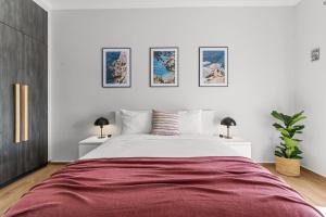 a bedroom with a large bed and three pictures on the wall at On The Port: Studio in Rafina