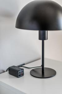 una lampada nera seduta sopra un tavolo di On The Port: Studio a Rafina