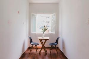 利馬的住宿－Miraflores Private Rooms - Guest House - Cocina Compartida - Terraza，一张桌子,两把椅子,花瓶上放着鲜花