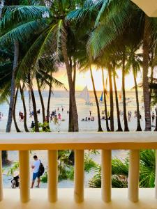 einen Balkon mit Blick auf einen Strand mit Palmen in der Unterkunft LA FIESTA RESORT in Boracay