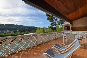 eine Terrasse mit 2 Stühlen und einem Tisch auf dem Balkon in der Unterkunft élégante villa avec piscine privée près de cassis in Carnoux