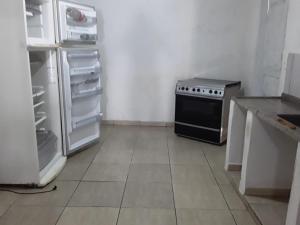 eine Küche mit einem Herd und einem offenen Kühlschrank in der Unterkunft Pousada do Toninho in Peruíbe