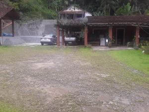 a house with a car parked in front of it at Pousada do Toninho in Peruíbe