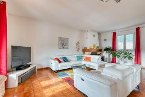 ein Wohnzimmer mit weißen Möbeln und einem Flachbild-TV in der Unterkunft élégante villa avec piscine privée près de cassis in Carnoux
