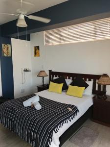 um quarto com uma cama grande com almofadas amarelas e pretas em Hoedjiesbaai Hotel em Saldanha
