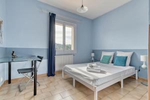 a bedroom with a bed and a desk and a window at élégante villa avec piscine privée près de cassis in Carnoux +52 photos
