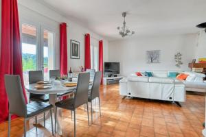 ein Wohnzimmer mit einem weißen Sofa, einem Tisch und Stühlen in der Unterkunft élégante villa avec piscine privée près de cassis in Carnoux