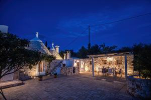 a stone house with a patio at night at TrullOlive in Ostuni