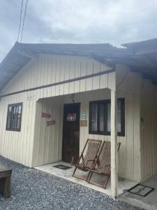 ein kleines Gebäude mit einer Tür und einer Veranda in der Unterkunft Casa 01,02 in Bombinhas