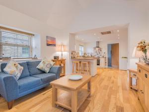 a living room with a blue couch and a kitchen at 1 Bed in Alston SZ499 in Leadgate