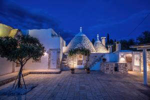 a white building with a tree in front of it at TrullOlive in Ostuni