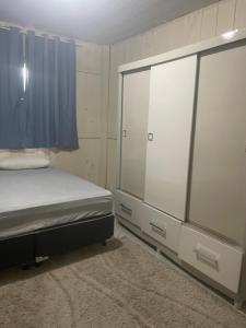 sypialnia z łóżkiem i dużym oknem w obiekcie Casa 01,02 w mieście Bombinhas