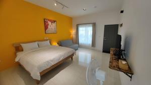 een slaapkamer met een bed en een gele muur bij 雲上 Villa in Hengchun +16 foto's