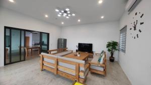 een woonkamer met een bank en een tv bij 雲上 Villa in Hengchun