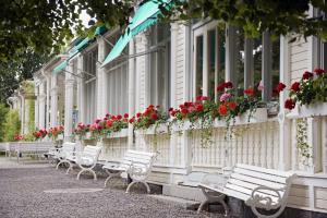 rząd białych ławek przed budynkiem z kwiatami w obiekcie Söderköpings Brunn w mieście Söderköping