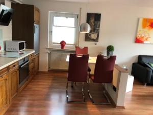 a kitchen with a table and chairs in a room at Ferienwohnung Hedi in Mastershausen