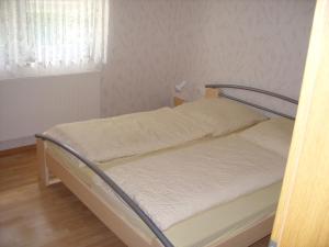 Bett in einem kleinen Zimmer mit Fenster in der Unterkunft Haus Eichhölzle in Bichishausen
