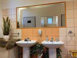 a bathroom with two sinks and a large mirror at Ubytovanie v Rožňave in Brzotín