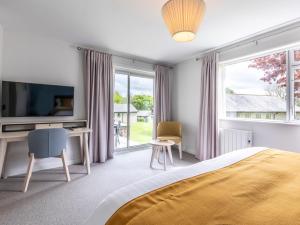 a bedroom with a bed and a tv and a window at 2 Bed in St. Mellion 87715 in St. Mellion