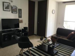 uma sala de estar com um sofá e uma televisão em Apto amoblado en valle del lili en la ciudad de Cali em Cali