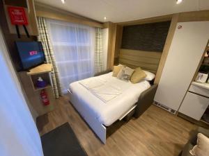 Un pequeño dormitorio con una cama y un televisor. en Neptunes Pod, en Fort William