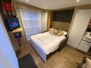 a small bedroom with a bed and a television at Neptunes Pod in Fort William