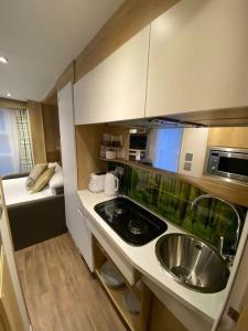 a small kitchen with a sink and a microwave at Neptunes Pod in Fort William