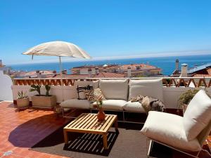 uma sala de estar com um sofá e um guarda-chuva em Private pool Sunset Terrace Apartment na Ericeira