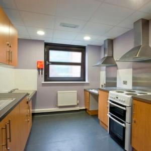 a kitchen with a stove and a window at Ian Baker House in London