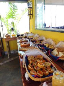 una linea a buffet con molti tipi di cibo diversi di Refúgio Pé da Serra - Chalés a São Roque de Minas