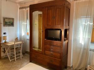 a large wooden cabinet with a television in it at Agriturismo LA TAVERNA DEL NONNO in Borzonasca