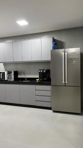 馬留坎普斯的住宿－Apartamento 3 quartos - completo - próximo ao Inhotim，厨房配有白色橱柜和不锈钢冰箱