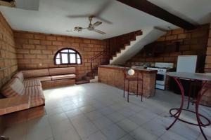 - un salon avec un ventilateur de plafond et une table dans l'établissement OYO Hotel Brisas Del Pacífico, à Puerto Vallarta