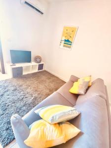 sala de estar con sofá y almohadas amarillas en La casetta en Nápoles