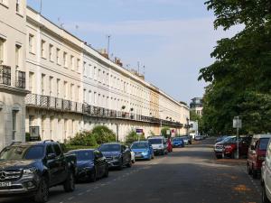 a row of cars parked on a street next to a building at Pittville Studios - By Suitely in Cheltenham