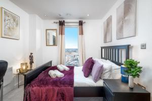 Un dormitorio con una cama con sábanas moradas y una ventana en LUX CONDO for 5 Slough Elizabeth line free parking, en Slough