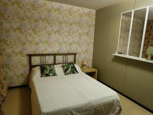 a bedroom with a bed with flowers on the wall at Apartment Nilsiä in Kuopio