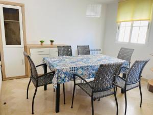 d'une table à manger avec des chaises et un chiffon de table bleu et blanc. dans l'établissement La Vela, à Miramar