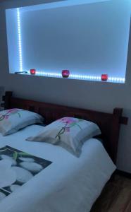 PanazolにあるChambre ZENの青いライト付きのベッドルームにベッド2台が備わります。