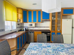 une cuisine avec des armoires jaunes et une table avec des chaises dans l'établissement La Vela, à Miramar