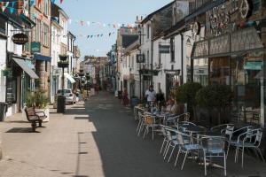 a city street with tables and chairs on a sidewalk at Stunning Penthouse in Penzance "Amazing Sea Views" in Penzance