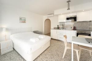 a white bedroom with a white bed and a desk at WELCS ESTUDIO 120 EMP cerca del mar in Empuriabrava