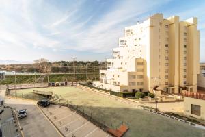 a tennis court in front of a building at WELCS ESTUDIO 120 EMP cerca del mar in Empuriabrava