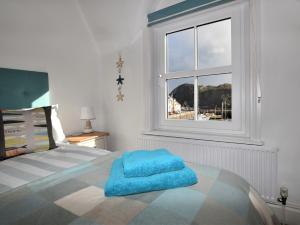 a bedroom with a bed with a blue towel on it at 4 Bed in Ilfracombe 45121 in Ilfracombe