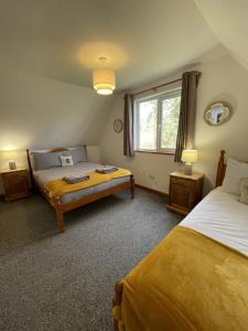 1 dormitorio con 2 camas y ventana en Hideaway Lodge Hengar Manor 4 bed sleeps 8 to10 en Michaelstow
