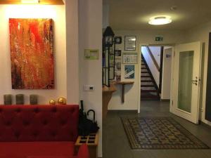 a living room with a red couch and a painting on the wall at Fachwerk-Hotel Eisenbart in Hannoversch Münden