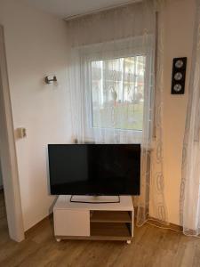 a flat screen tv sitting on a stand in front of a window at Ferienwohnung in Oberstdorf mit wundervollem Bergpanorama in Oberstdorf