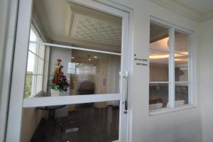 a door with a window and a vase of flowers at Maulidia Hotel & Convention Center in Jambi