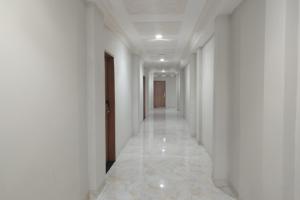 a corridor of a building with white walls and ceilings at Maulidia Hotel & Convention Center in Jambi